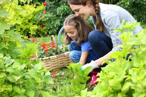 Worker demonstrating pruning technique on a community garden plot